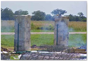 Installing field fence alongside stone columns